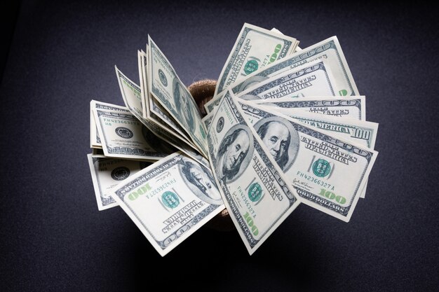 Dólares americanos dinheiro dinheiro no saco na mesa preta no quarto escuro