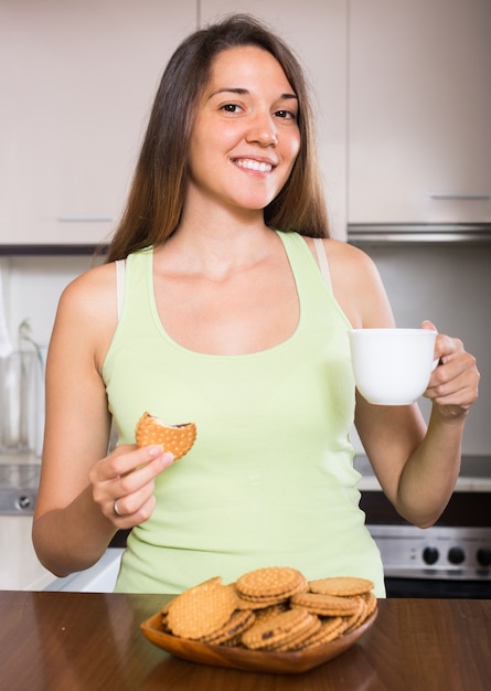 Dona de casa com biscoitos na cozinha