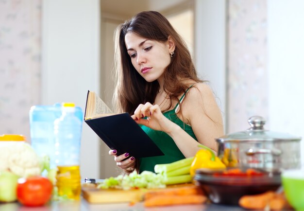 Dona de casa pensativa com livro de receitas