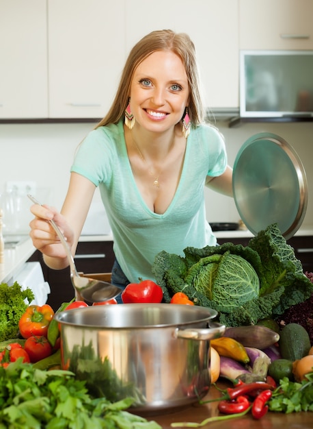 Dona de casa positiva cozinhar legumes frescos