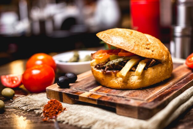 Doner de cordeiro no pão com pepino picles batatas fritas e tomate horizontal