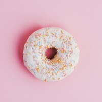 Donut com cobertura polvilhe em fundo rosa