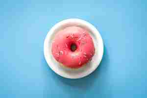 Foto grátis donut com glacê rosa em um fundo colorido isolado