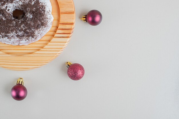 Donut de chocolate com bolas de Natal.