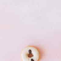 Foto grátis donut decorado com grãos de café no fundo do fundo rosa