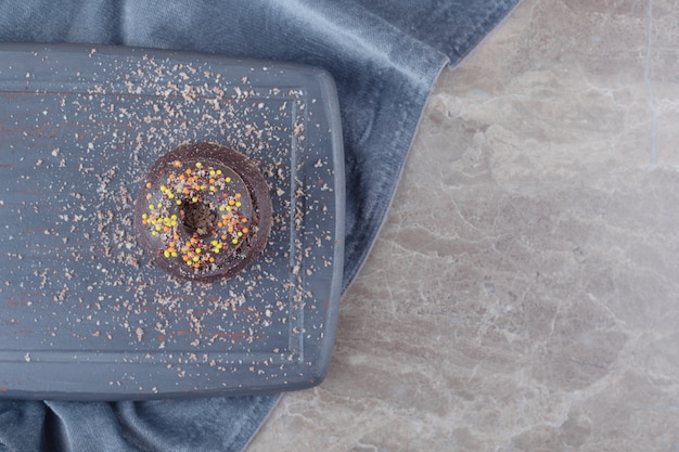 Donut em um pequeno bolo de chocolate em uma placa de mármore