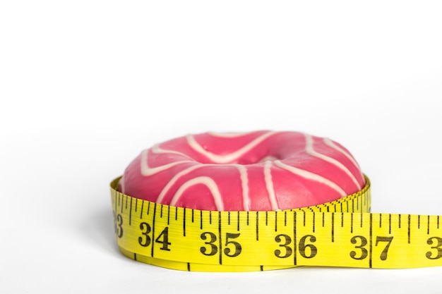 Foto grátis donut rosa e medir o conceito de ganho de peso e perda de peso