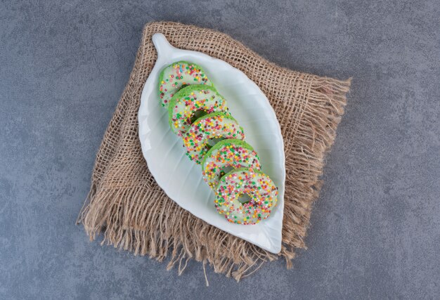 Donuts decorados com granulado na chapa branca.