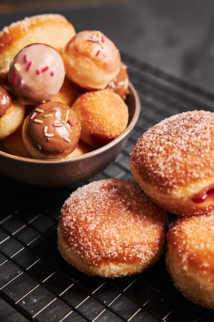 Donuts fritos com açúcar e creme em uma mesa preta