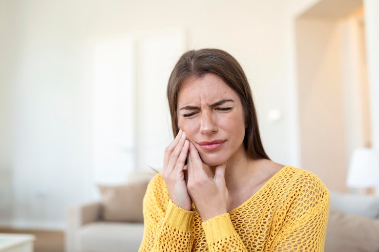 Foto grátis dor de dente e odontologia mulher jovem e bonita que sofre de terrível dor de dentes forte tocando a bochecha com a mão fêmea sentindo doloroso dor de dente cuidados dentários e saúde conceito alta resolução
