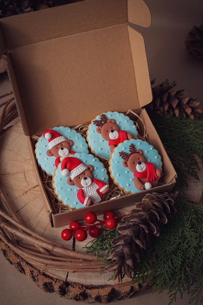 Dos biscoitos de Natal frescos e coloridos doces em uma caixa em um tronco de árvore