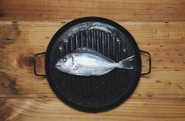 Dourada fresca do mar na grelha pronta para cozinhar