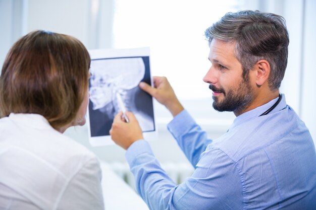 Doutor que discute raios-X com o paciente