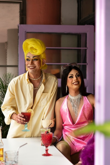 Drag queens sorridentes de tiro médio dentro de casa