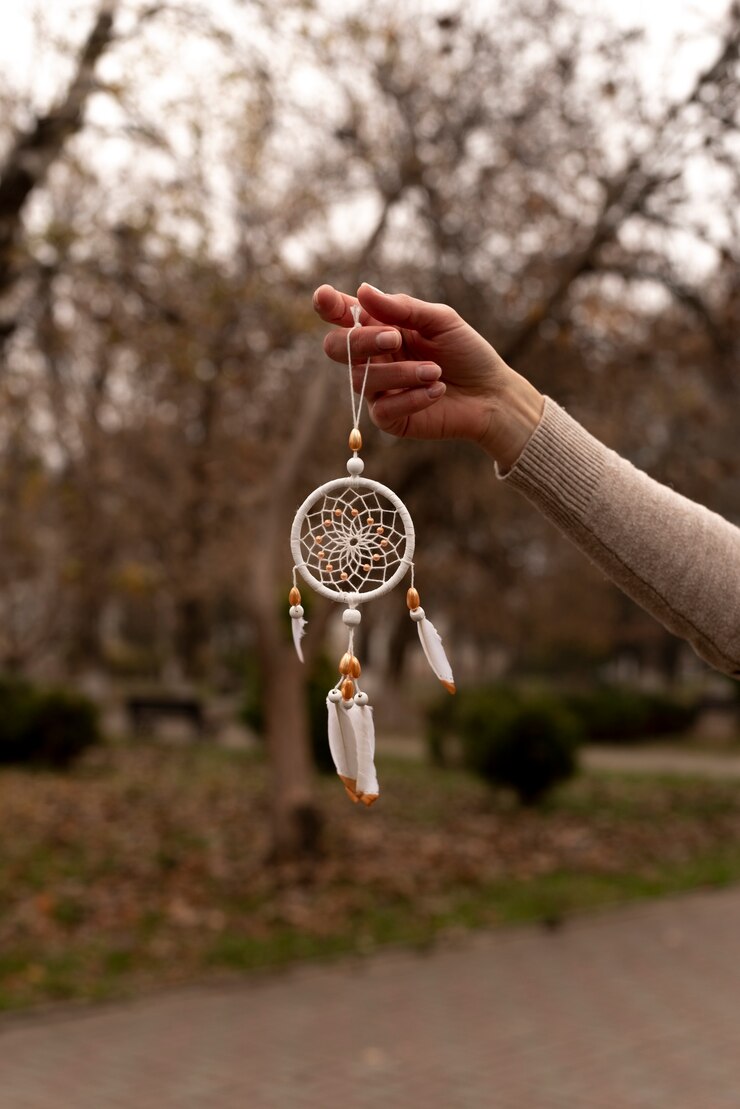 Foto grátis dreamcatcher segurado manualmente ao ar livre