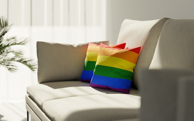 Duas almofadas pintadas nas cores raibow da bandeira lgbt repousam no sofá.