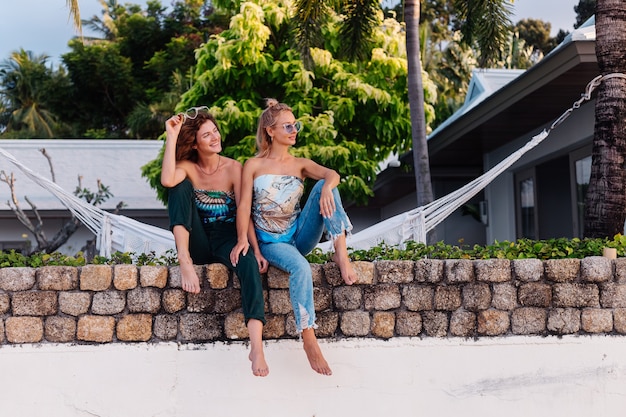 Duas amigas felizes com óculos de sol de férias em um país tropical