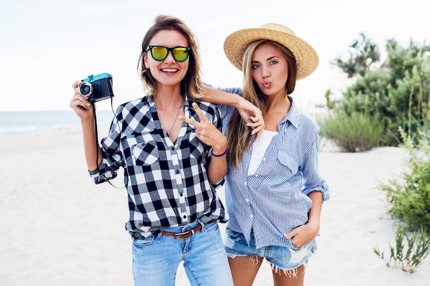 Duas amigas felizes se divertindo na praia