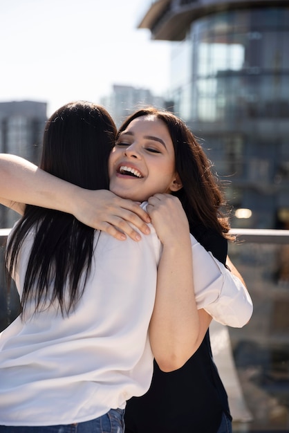 Duas amigas se abraçando após se verem em um terraço na cobertura
