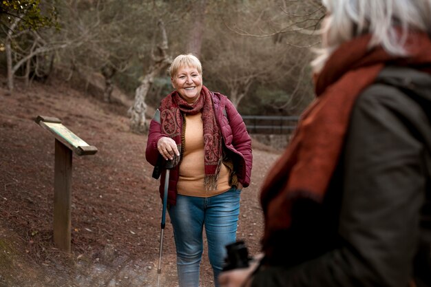 Foto grátis duas amigas seniores desfrutando de uma caminhada juntos na natureza