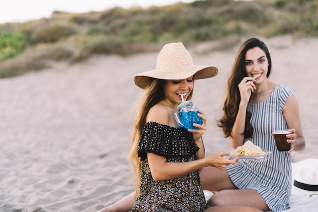 Duas amigas sentadas na praia