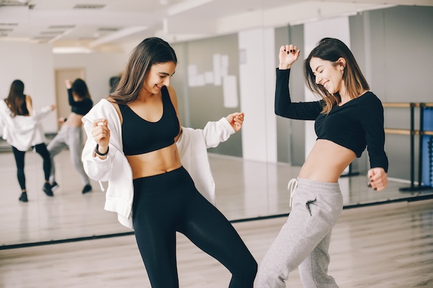 Foto grátis duas belas meninas delgadas fazendo dança e ginástica no salão de dança