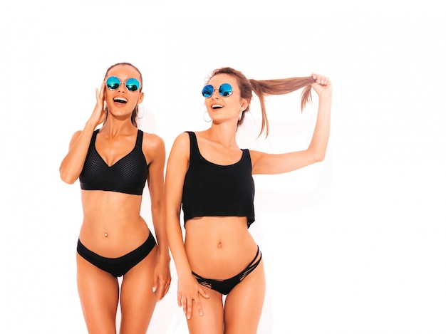 Foto grátis duas belas mulheres sorridentes sexy em lingerie preta. modelos quentes na moda se divertindo. meninas isoladas em óculos de sol
