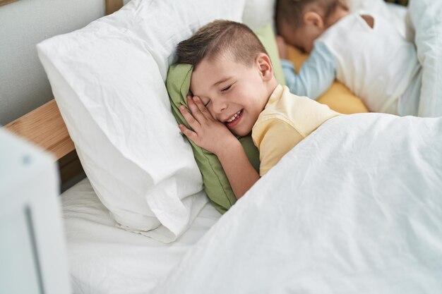 Duas crianças deitadas na cama dormindo no quarto