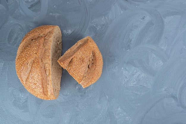 Duas fatias de pão de centeio expostas na mesa de mármore.