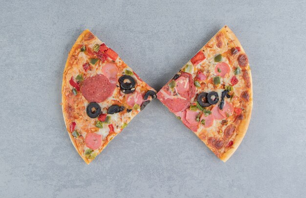 Duas fatias de pizza expostas em mármore