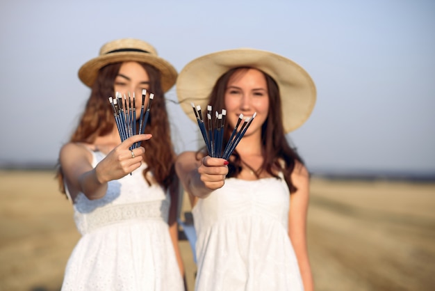 Duas garotas em um vestido branco, pintura em um campo