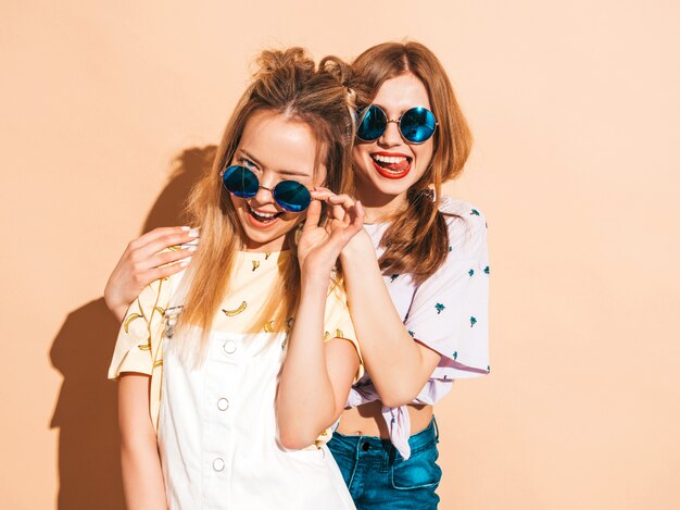 Duas garotas loiras hipster sorrindo lindas jovens em roupas de camiseta colorida na moda verão.