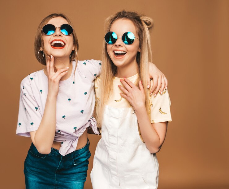 Foto grátis duas garotas loiras hipster sorrindo lindas jovens em roupas de camiseta colorida na moda verão.