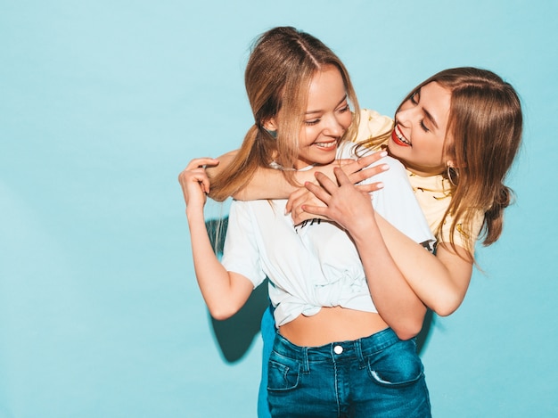 Duas garotas loiras hipster sorrindo lindas jovens em roupas de camiseta colorida na moda verão.