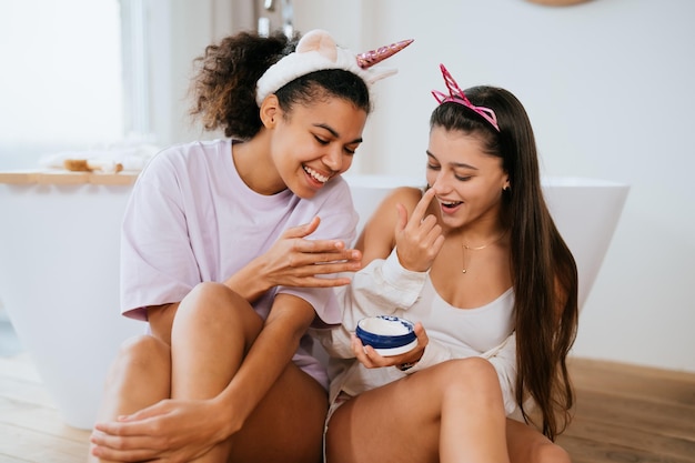 Duas garotas no banho brincando com creme facial