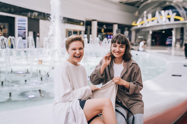 Duas garotas se divertem no shopping, uma fonte