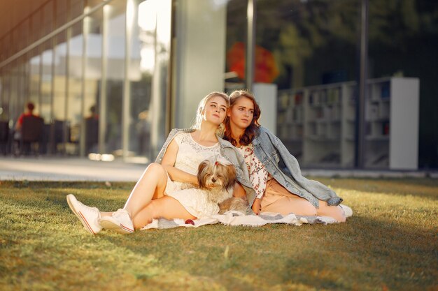 Duas garotas sentado em um parque com um cachorrinho