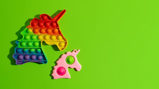 Duas inquietações anti-stress - estale-o e uma covinha simples no fundo verde. novo brinquedo anti-stress sensorial para crianças e adultos. coloração do arco-íris na moda, faixa grande.