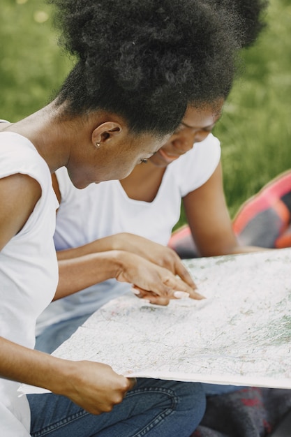 Duas irmãs afro-americanas olhando em um mapa em um parque