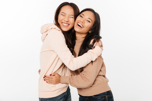 Duas irmãs muito alegres asiáticas das senhoras