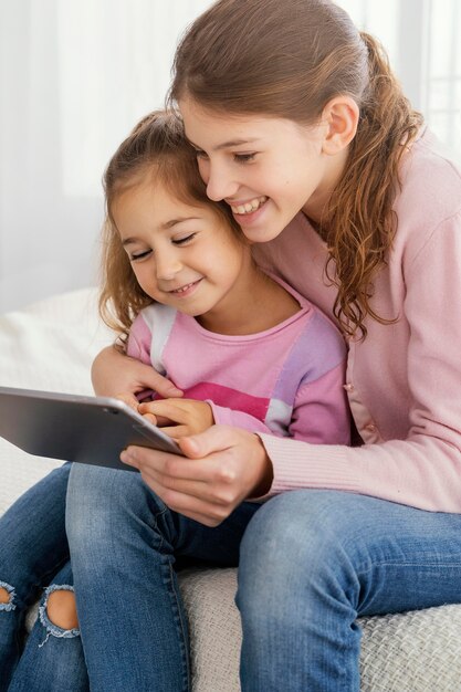 Duas irmãs usando tablet juntas em casa