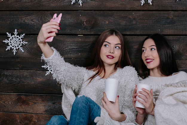 Duas jovens amigas engraçadas sorrindo e se divertindo, fazem salfie