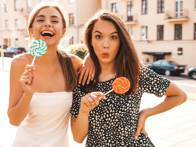 Duas jovens bonitas garotas hipster sorridentes em roupas da moda verão