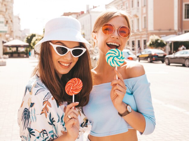 Duas jovens bonitas hipster garotas sorridentes em roupas da moda verão e chapéu Panamá.