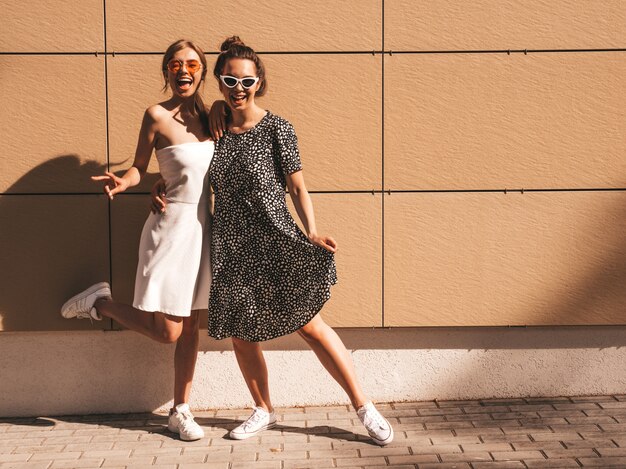 Duas jovens bonitas sorridentes garotas hipster no verão na moda vestido.