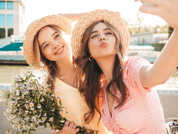 Duas jovens lindas sorrindo hippie com um vestido de verão da moda