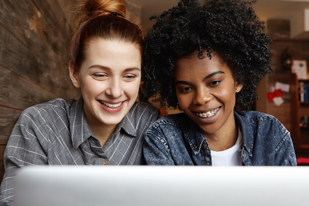 Foto grátis duas lésbicas felizes sentadas em frente a um laptop aberto juntas