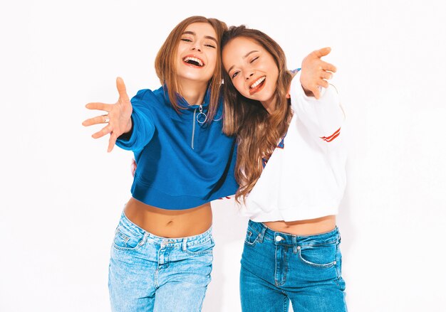 Duas lindas meninas sorridentes em roupas da moda no verão. mulheres despreocupadas. Modelos positivos