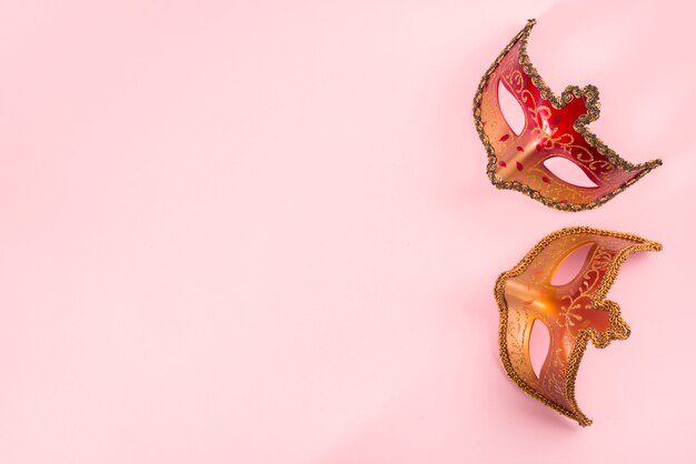 Duas máscaras de carnaval na mesa-de-rosa