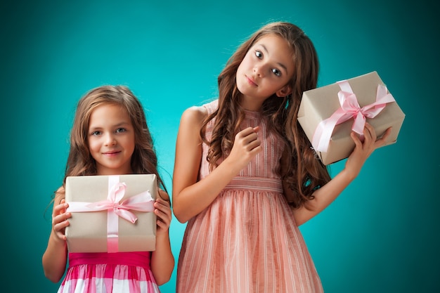 Duas meninas alegres bonitos com caixas de presente